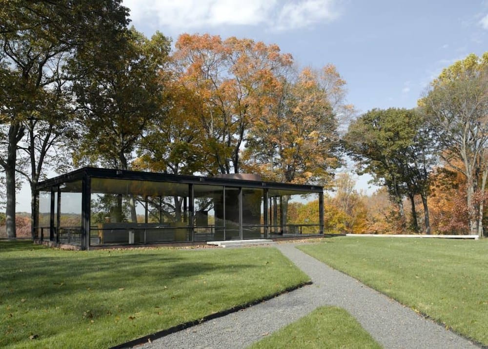 Modern glass pavilion amid autumn trees, scenic outdoor event space, Fall foliage, nature, relaxation, outdoor venue.