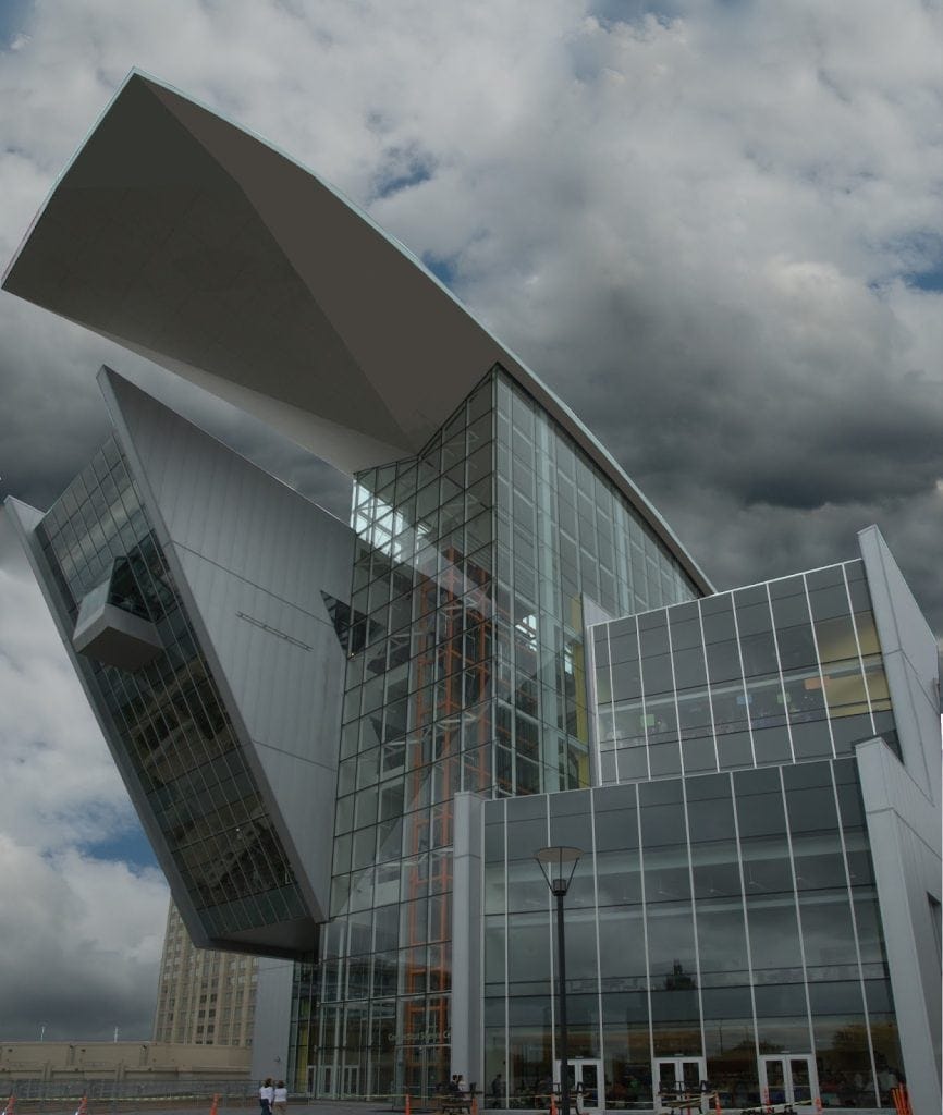 Futuristic modern building with glass facade, architecture, urban infrastructure, daytime cloudy sky.