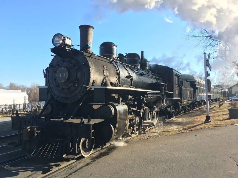 Vintage steam locomotive train at QuestForDirections museum, historic transportation display, outdoor railway exhibit, classic engine, transportation history.