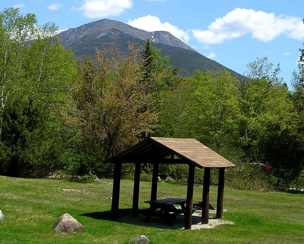 Serene mountain landscape with picnic shelter and lush greenery, ideal for outdoor adventures and scenic views.