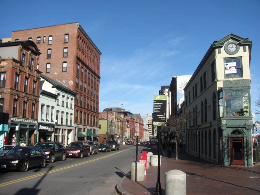 Colorful downtown street with historic buildings and storefronts in a vibrant urban setting.