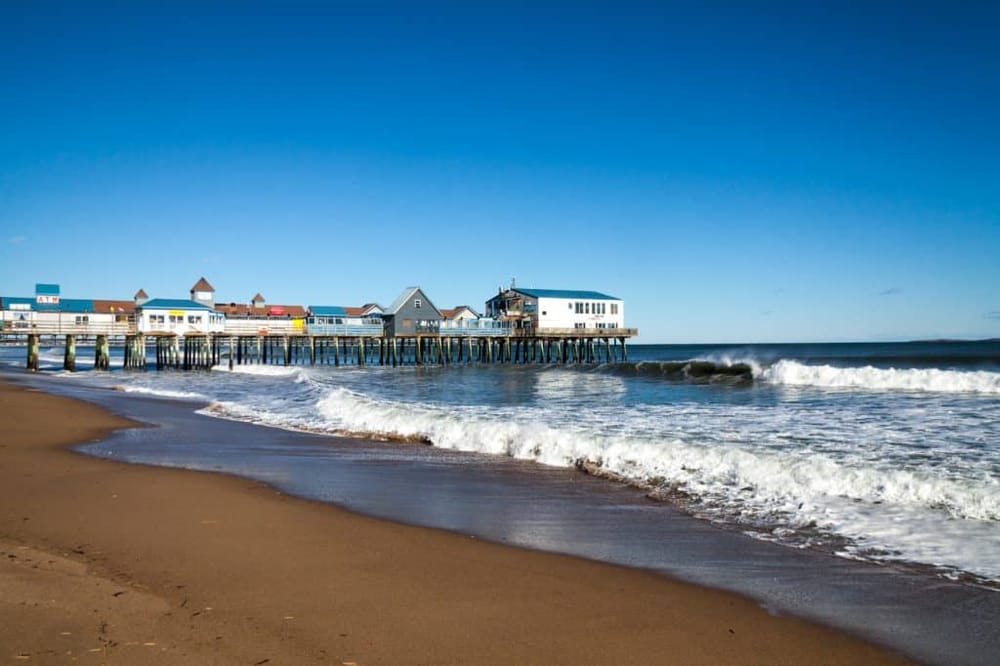 Colorful beach pier with shops and waves at the shoreline, perfect for seaside relaxation.