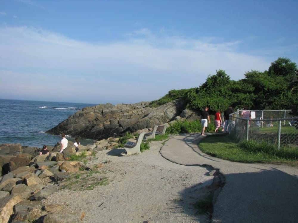 Seaside park with walking trail, benches, and ocean view, popular destination for relaxation and outdoor activities.