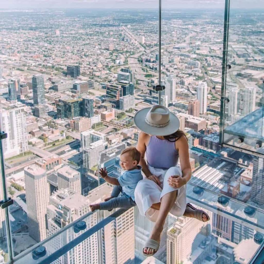 Stunning city skyline view from a skyscraper observation deck with woman and child.