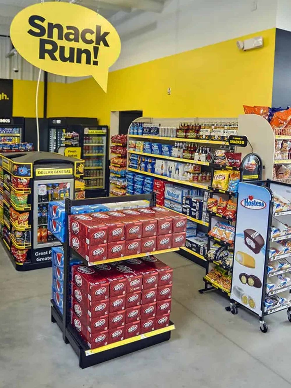 Snack run at convenience store, snack shelves with chips and treats, bright yellow wall, and promotional sign.