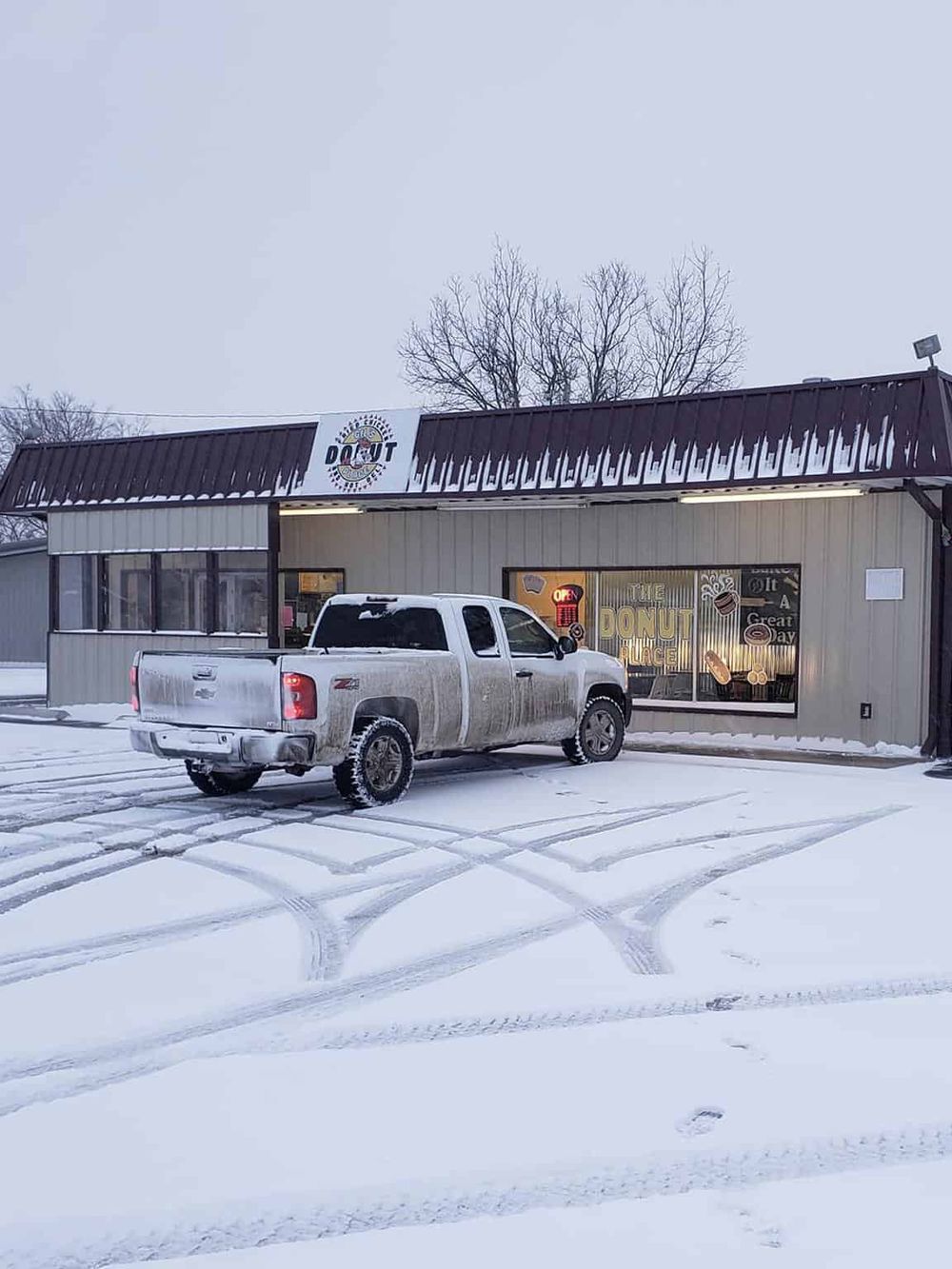 Neurological signs in building, snow-covered parking lot, truck in front of QuestForDirections store.