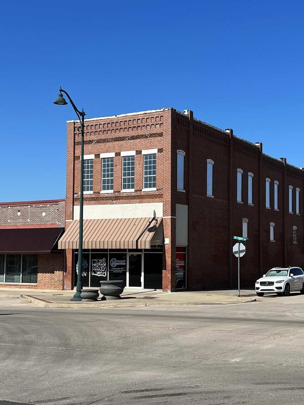 Historic brick building with storefront on a sunny day, representing local businesses and community hubs.