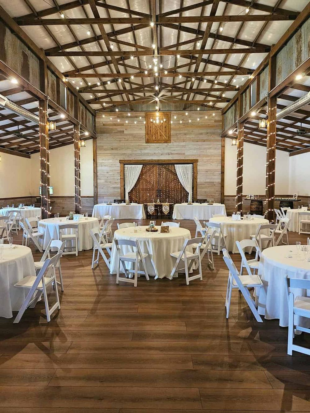 Rustic barn wedding reception venue with string lights and wooden accents, perfect for celebrations.