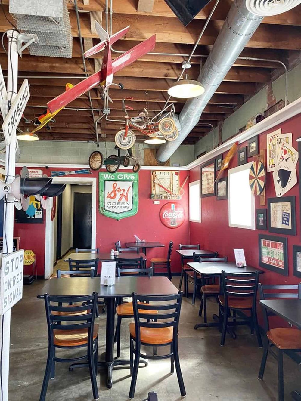 Colorful vintage-themed restaurant with hanging bicycles and retro decor, offering a nostalgic dining experience.