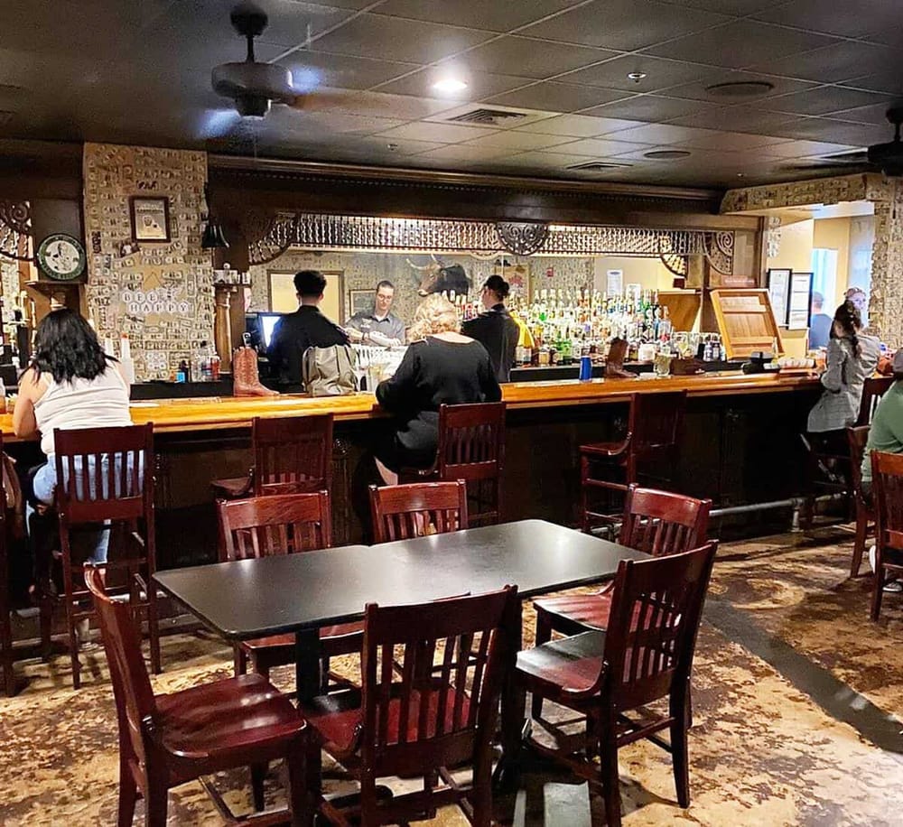 Cozy tavern with bar and dining area, perfect for exploring local cuisine and drinks. Authentic atmosphere with customers enjoying their time.