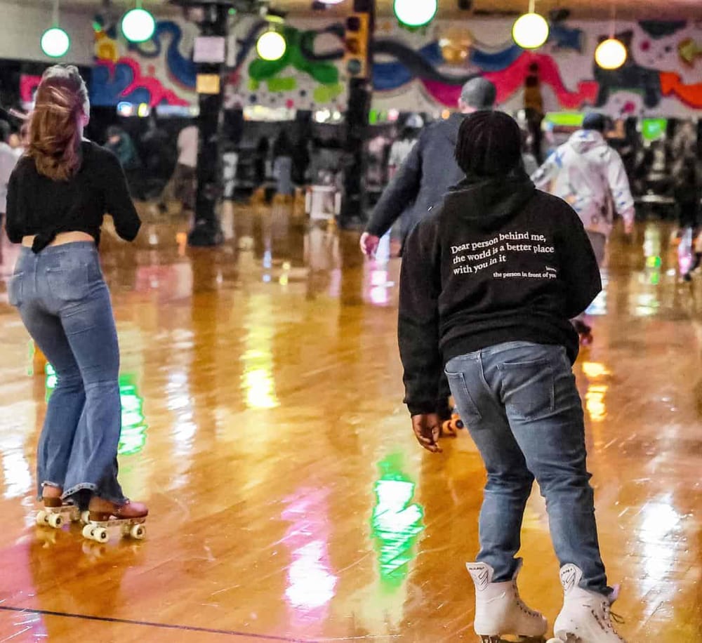 Roller skaters enjoying a vibrant indoor roller rink with colorful graffiti art and lively ambiance.