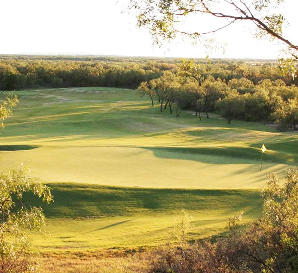 Serene golf course with lush green fairways and trees, ideal for outdoor recreation and scenic views.