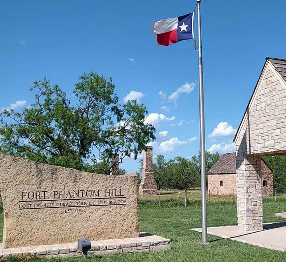 Historic Fort Phantom Hill Texas landmark with flagpole and clear blue sky.