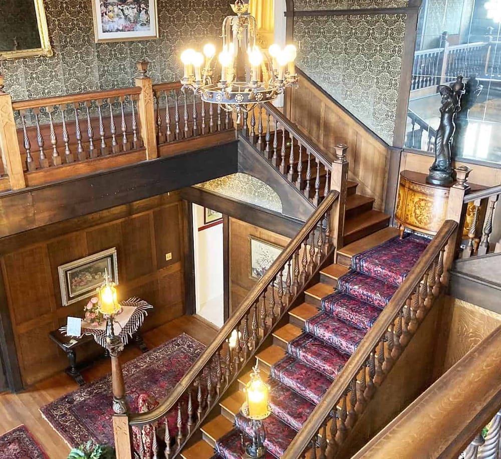 Elegant wooden staircase with intricate railing in vintage interior decor.