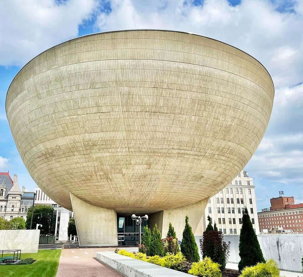 Modern museum building with unique bowl-shaped architecture in downtown cityscape.