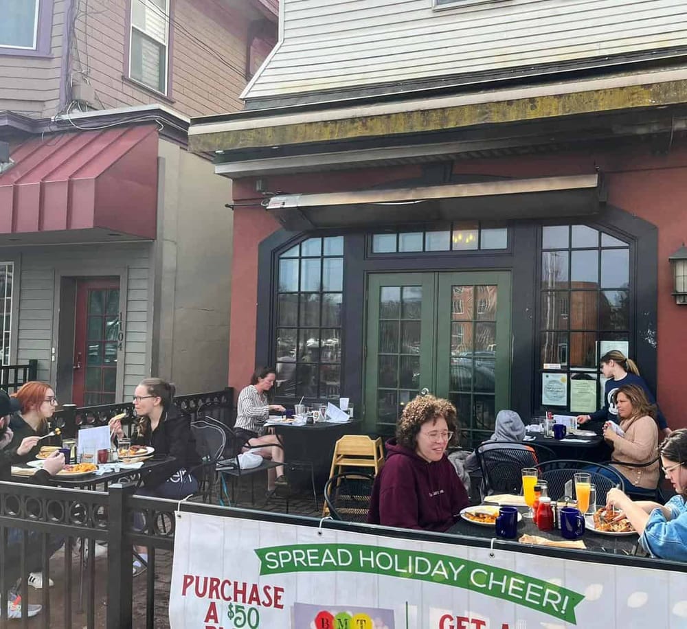 AlT text: Cozy outdoor dining patio at QuestForDirections restaurant in downtown.