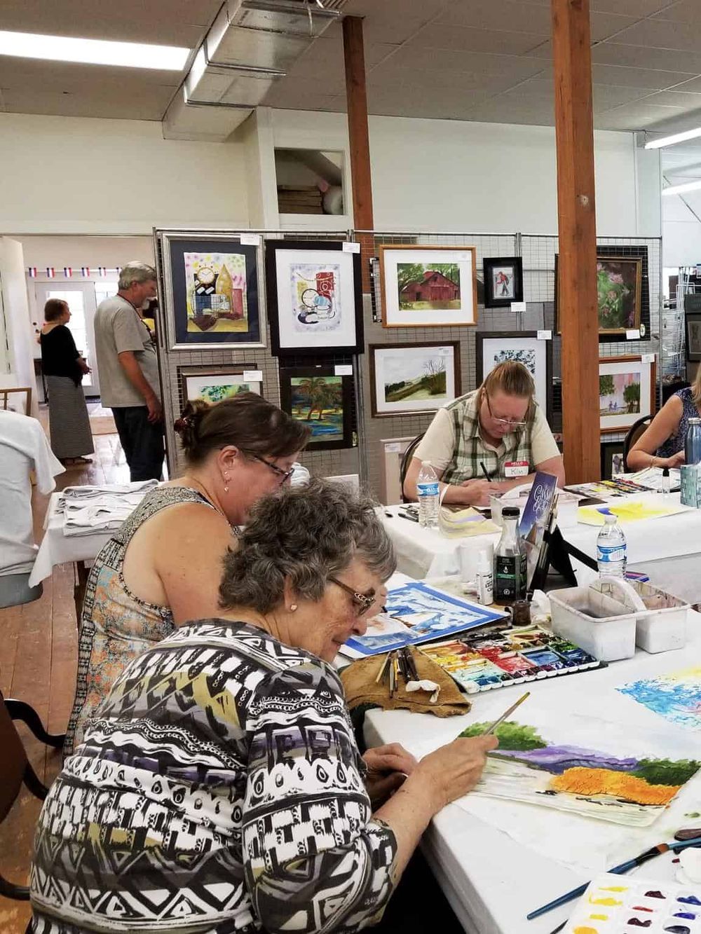 Colorful art workshop at QuestForDirections art event, showcasing local artists' paintings and community engagement.