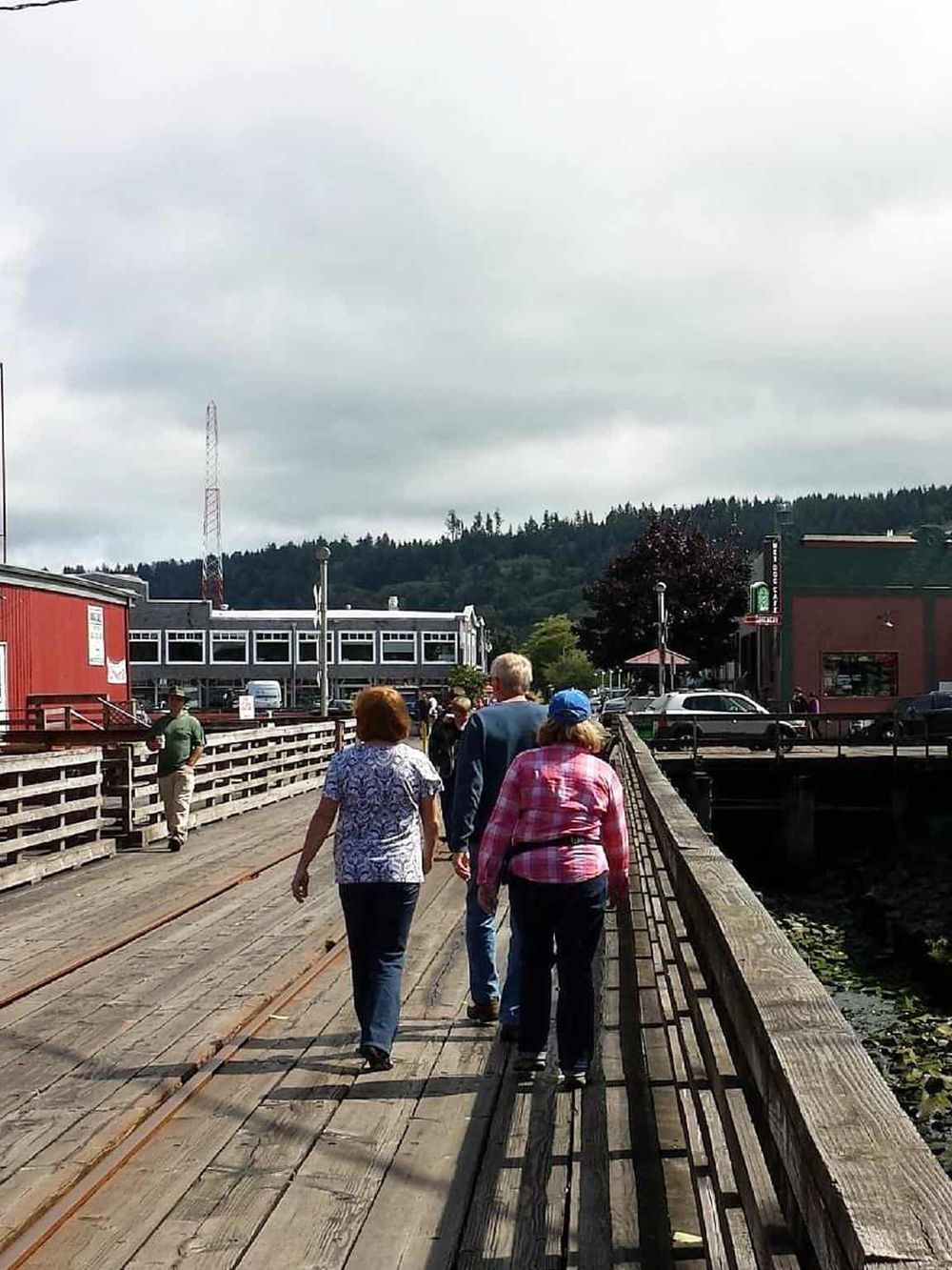 Scenic waterfront walk at Quest for Directions, featuring visitors exploring the historic pier and picturesque town ambiance.
