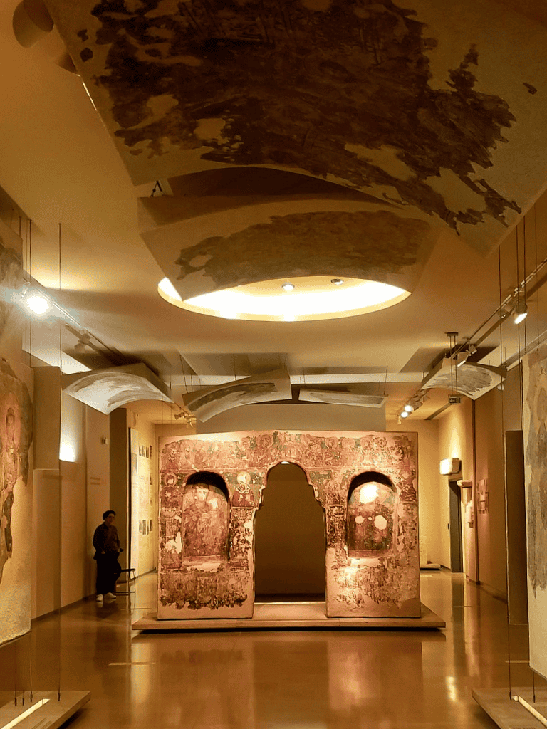 Ancient Roman fresco exhibit at QuestForDirections museum with historical artifacts and artwork.