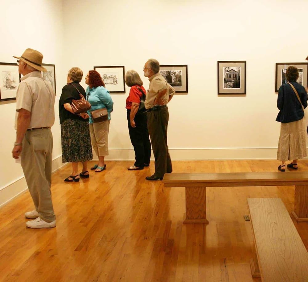 Colorful visitors viewing artwork in an art gallery or museum.