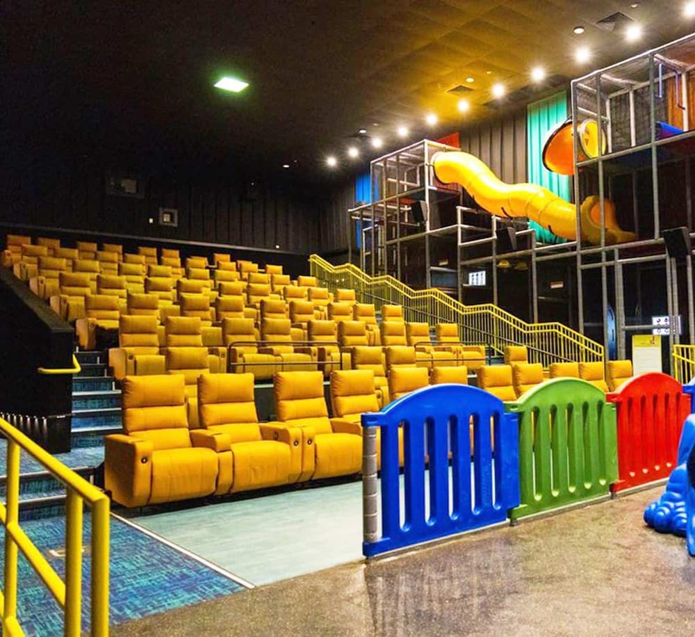 Colorful indoor playground with yellow seating and slides at QuestForDirections entertainment center.