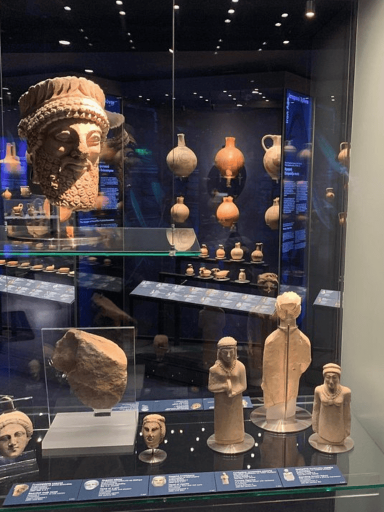 Ancient artifacts display at Quest for Directions museum, featuring sculptures, pottery, and historical relics.