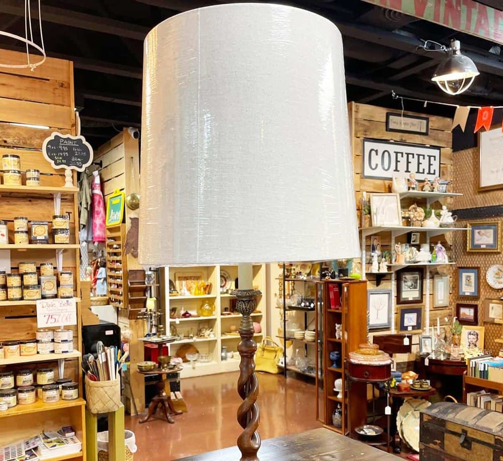 Elegant vintage-style lamp in a cozy thrift store with unique home decor and collectibles.