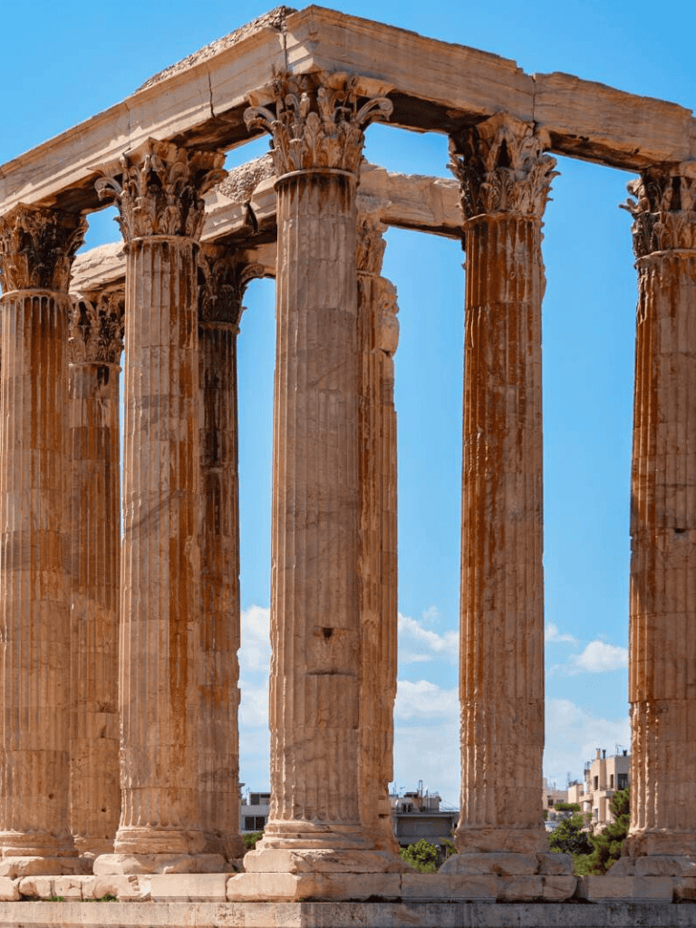 Ancient Greek temple ruins with tall columns under a clear blue sky.