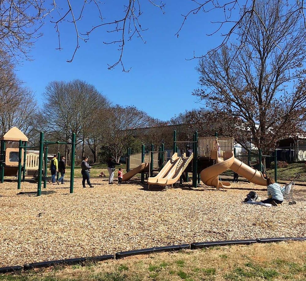 Children playing on playground equipment at a public park in fall.