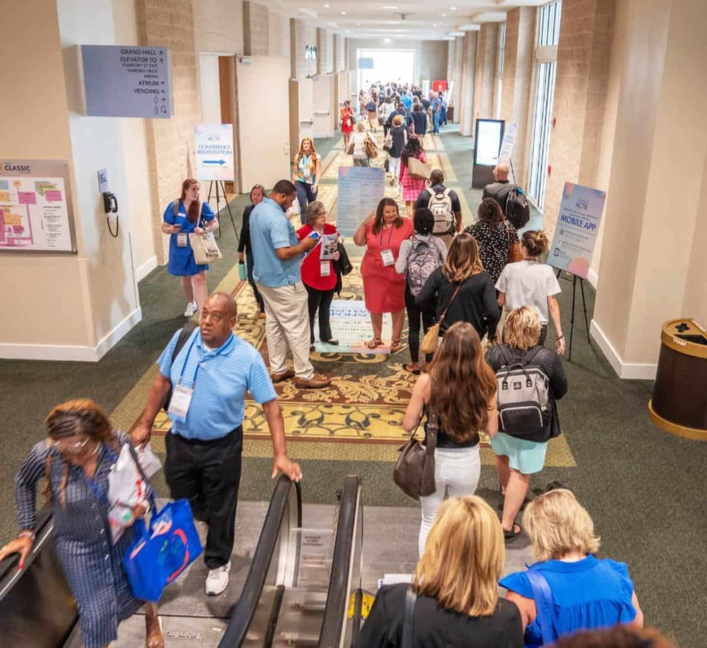 Conference attendees gathering in a spacious hotel lobby during a professional event or convention.