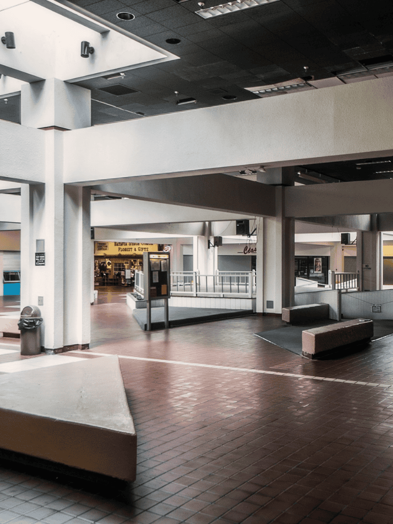 Bright indoor mall corridor with elevated walkways and storefronts at QuestForDirections.
