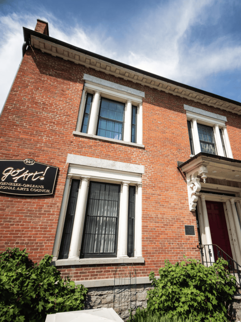Historic brick building with white columns and art gallery signage in Geneva-ottes.