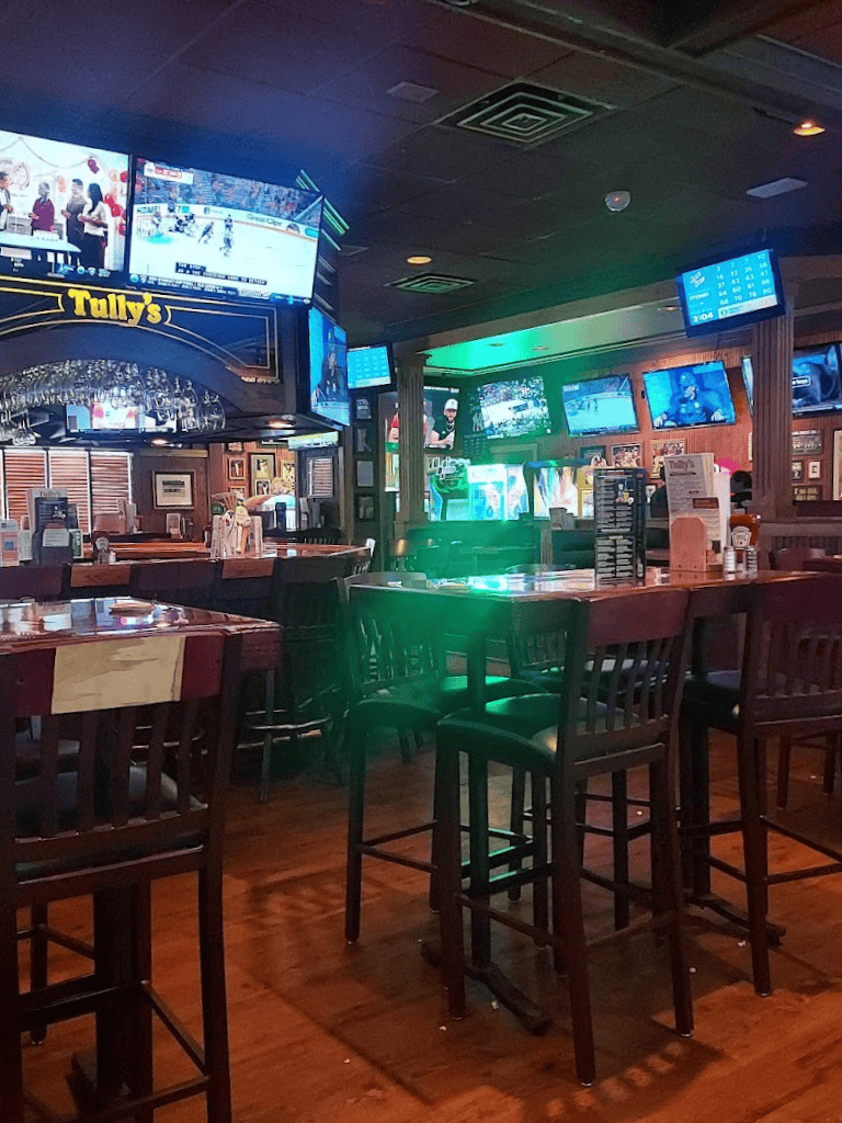 Cozy bar with multiple TV screens showing sports games, inviting atmosphere, ideal for socializing and live sports viewing.