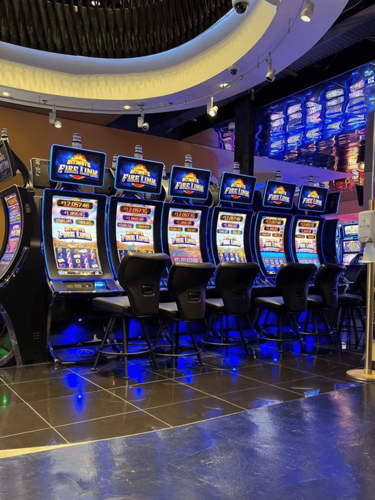 Slot machines at a gaming casino engaging players with digital screens in a vibrant entertainment setting.