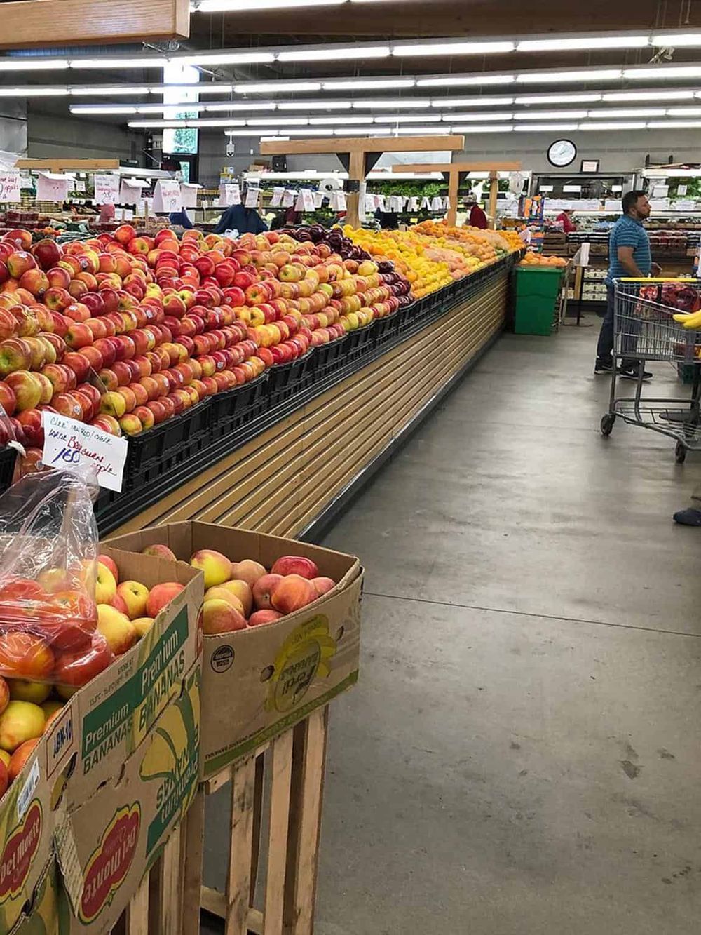 Fresh apples display at grocery store, clean and well-organized produce section.