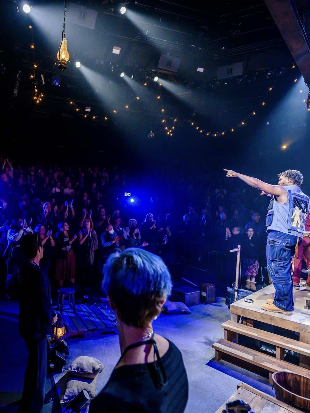 Vibrant live music concert scene with performer on stage and engaged audience, showcasing entertainment venues.