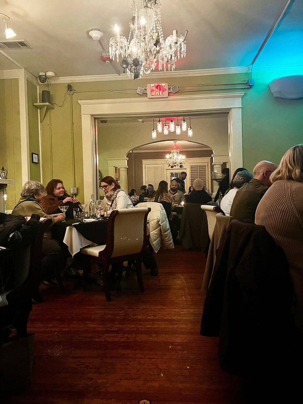 Comfortable upscale restaurant interior with elegant chandelier lighting and cozy dining atmosphere.