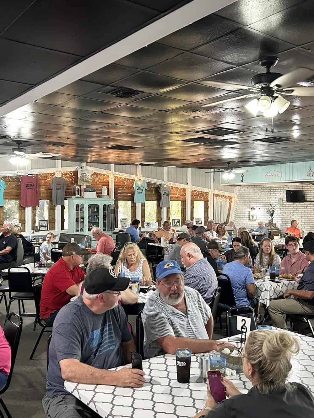 Busy restaurant filled with diverse diners enjoying meals together in a casual dining setting.