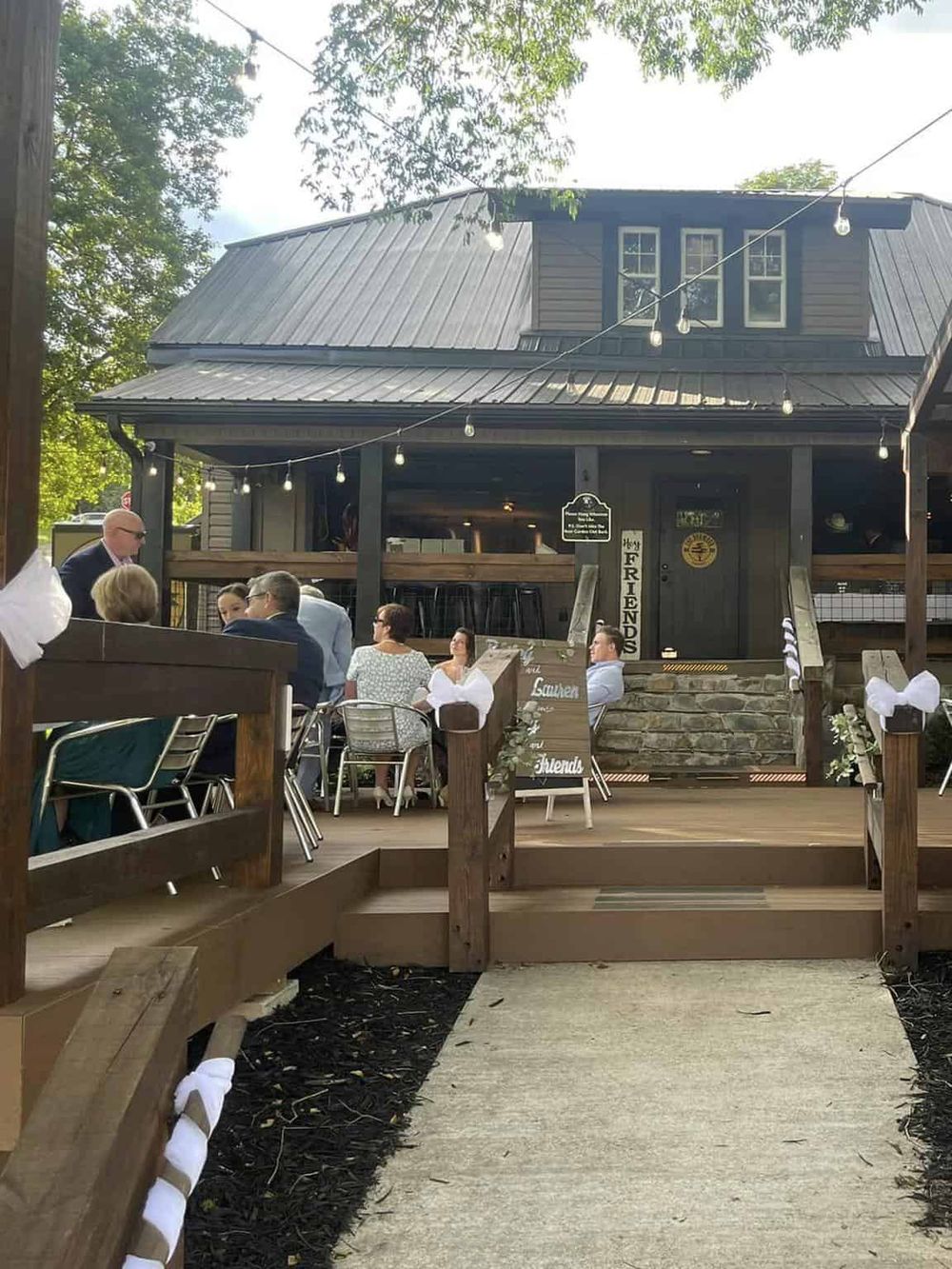 Charming outdoor dining at Quest for Directions, featuring a cozy house-style venue with string lights.