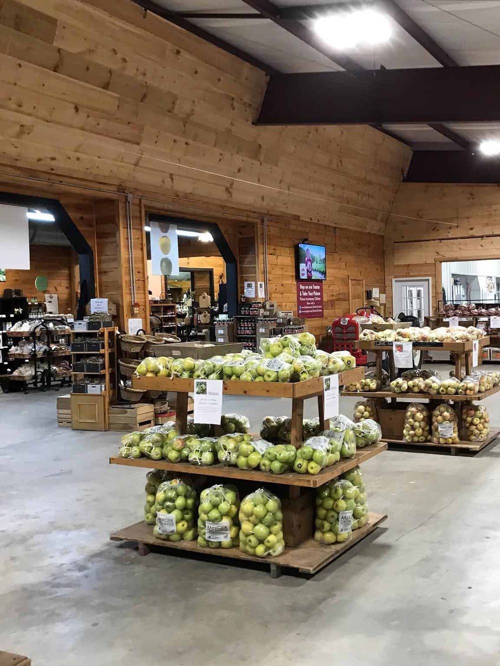 Fresh green apples displayed at farm stand interior for local produce shopping.