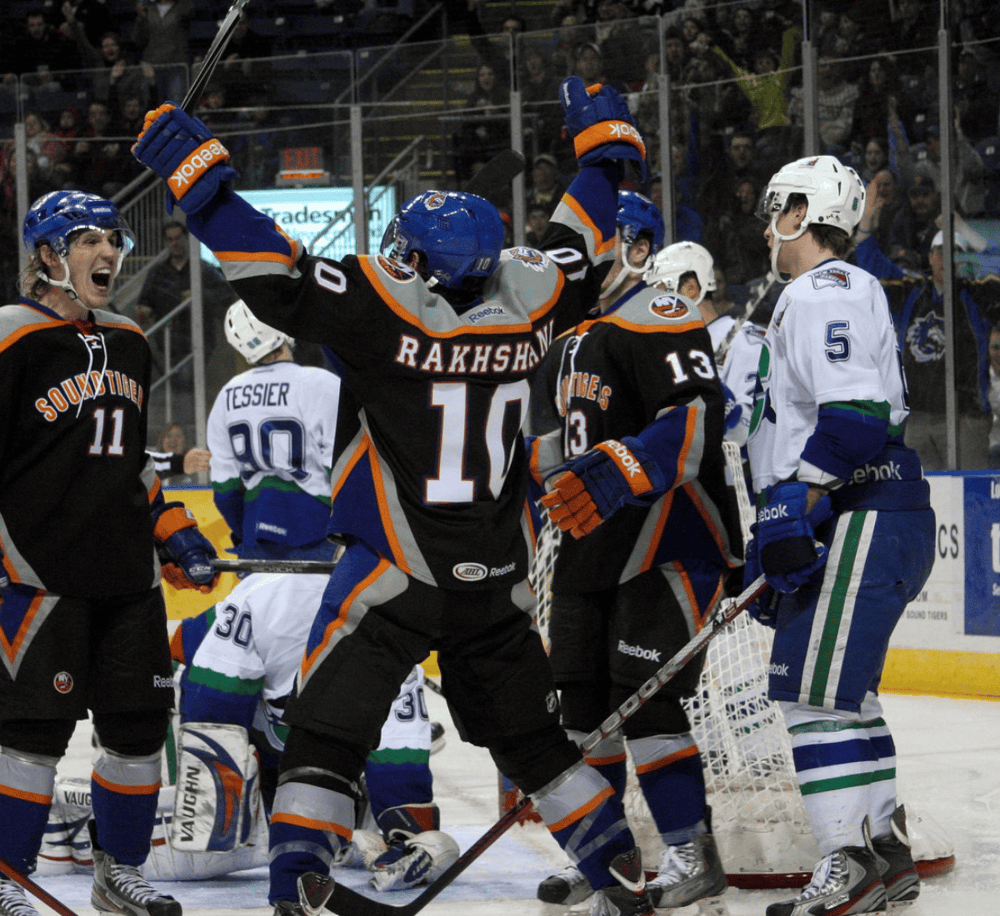 Celebrating hockey players on ice rink after victory, team victory celebration, sports team unity, thrilling hockey game moment.