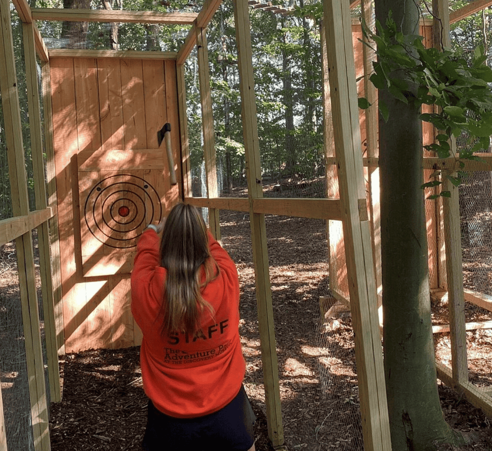 Archery target practice in a wooden outdoor range surrounded by trees.