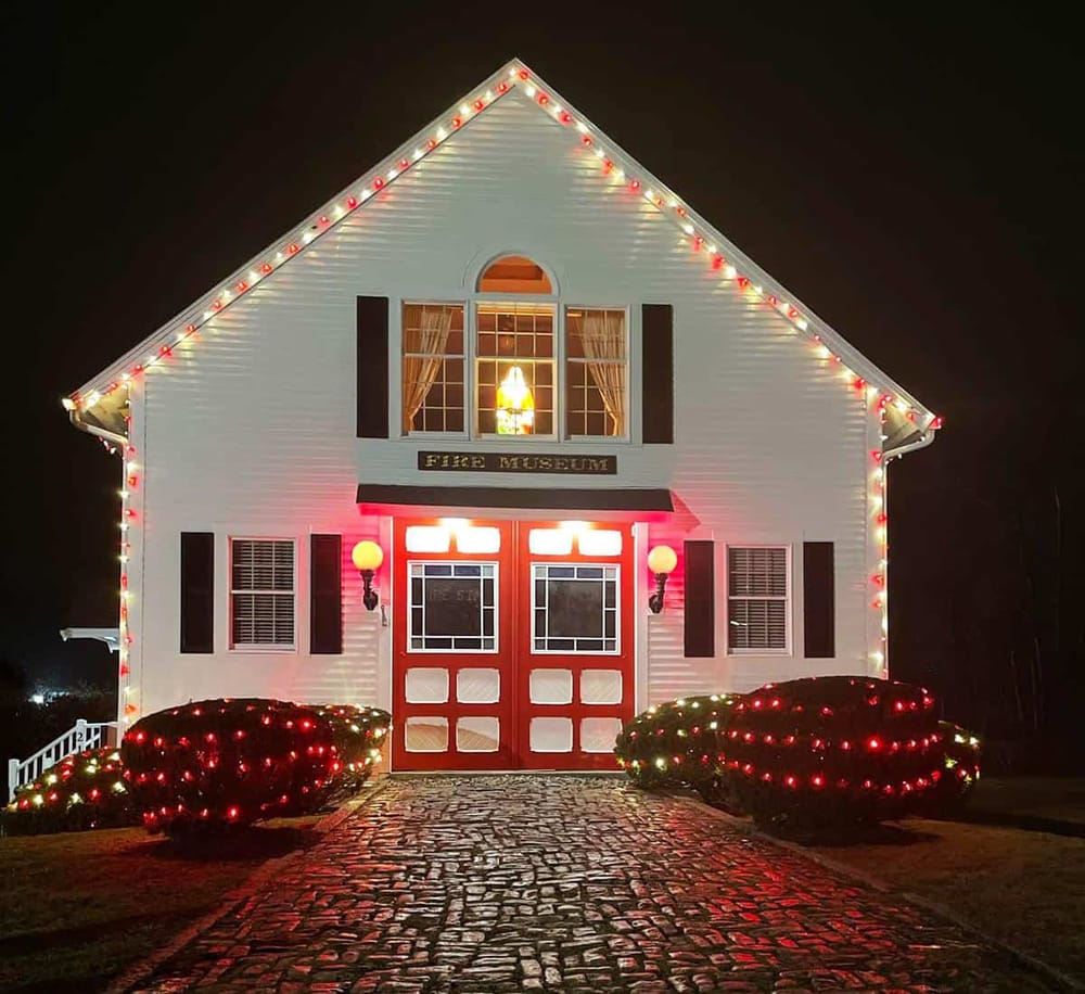 Colorfully decorated fire museum house illuminated at night, ideal for fire safety awareness and community events.