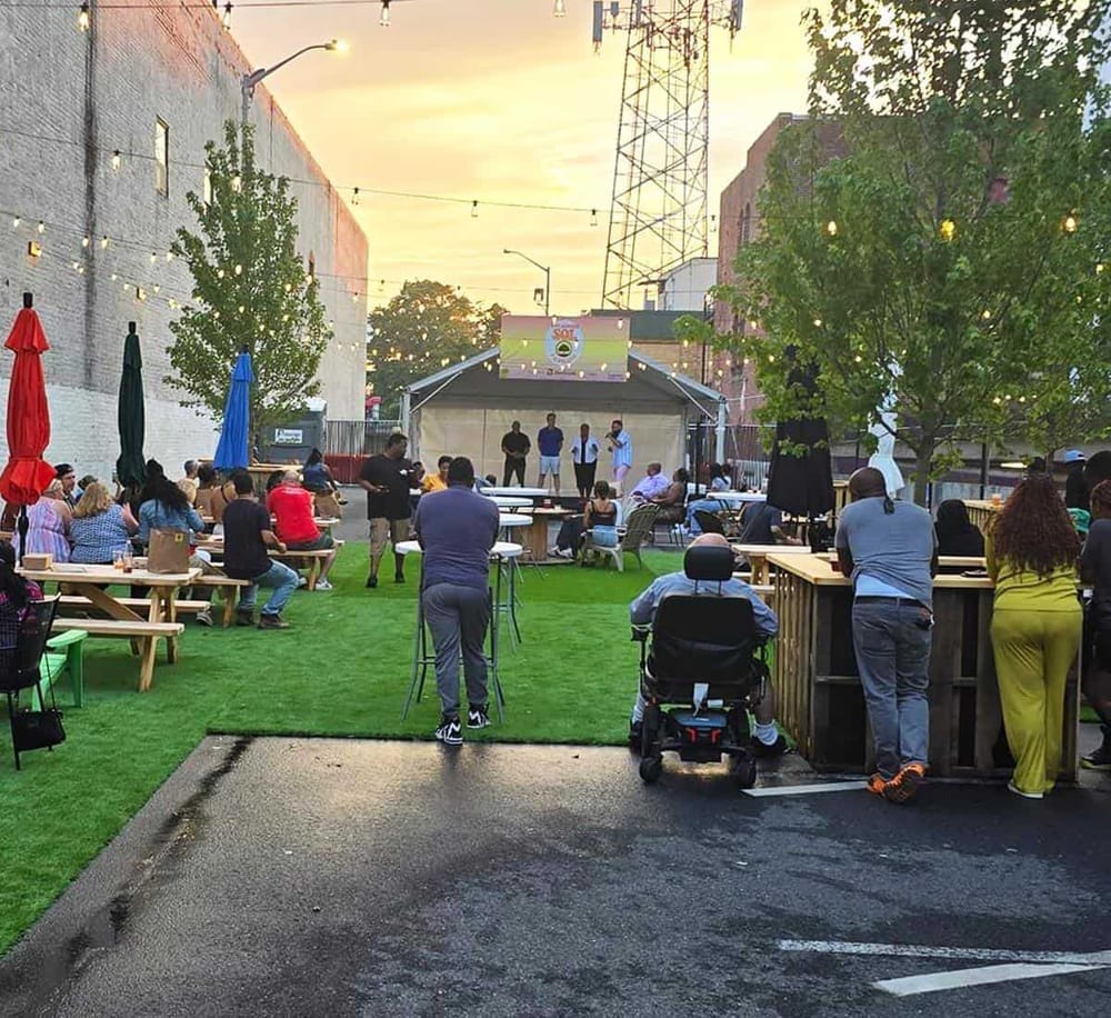 Outdoor community event with live performances and audience at sunset, highlighting local entertainment and social gathering spots.