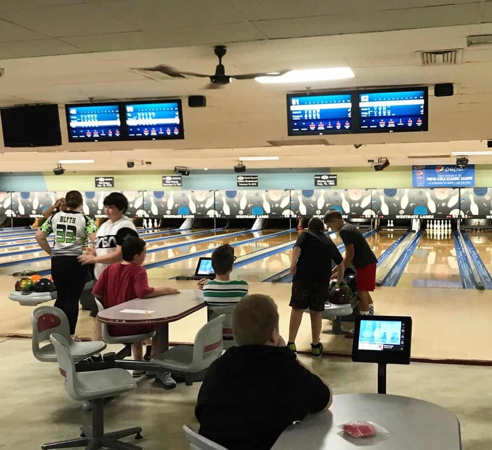 Brightly lit bowling alley with players aiming, scoring, and enjoying a fun game of bowling. Perfect for family entertainment and group outings.