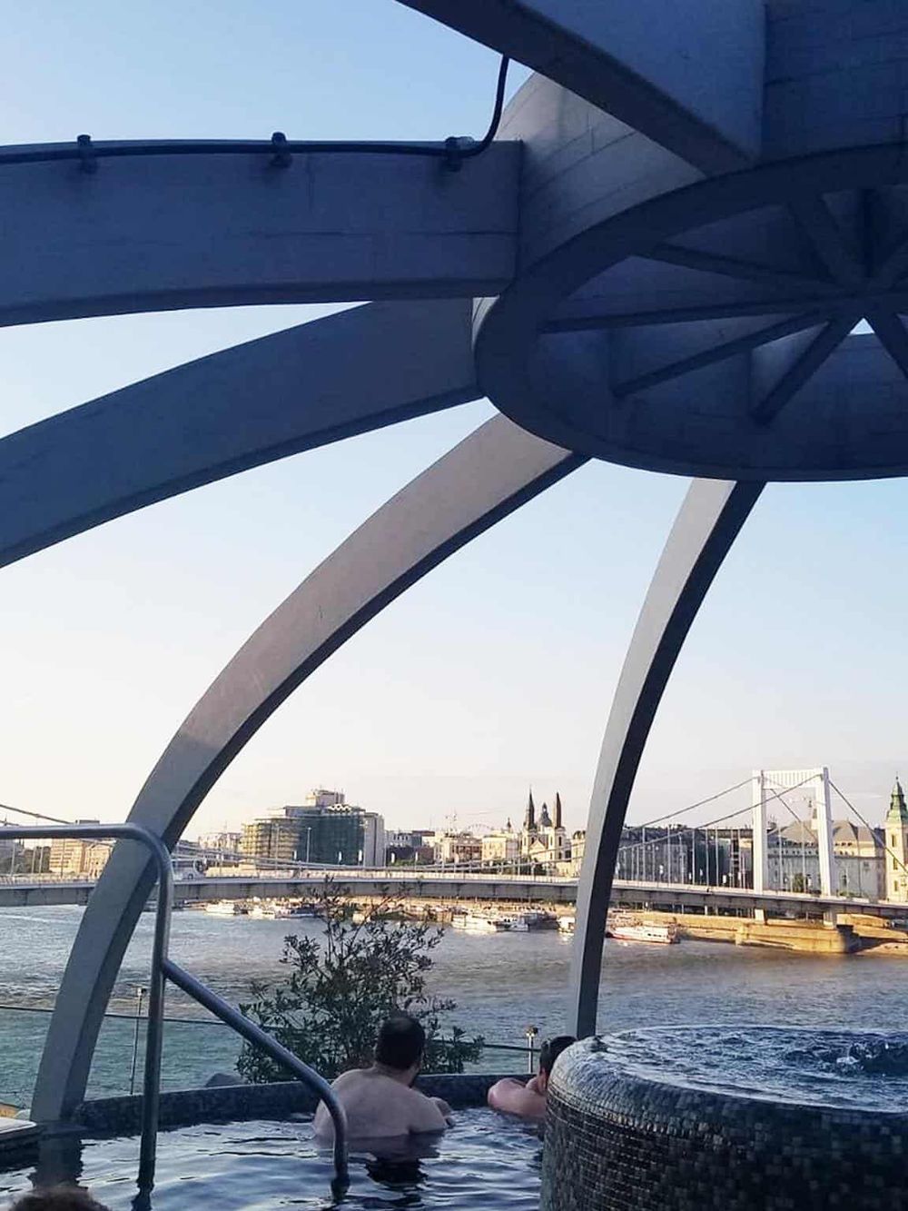 Relaxing river view hot tub in Budapest with city skyline in the background.