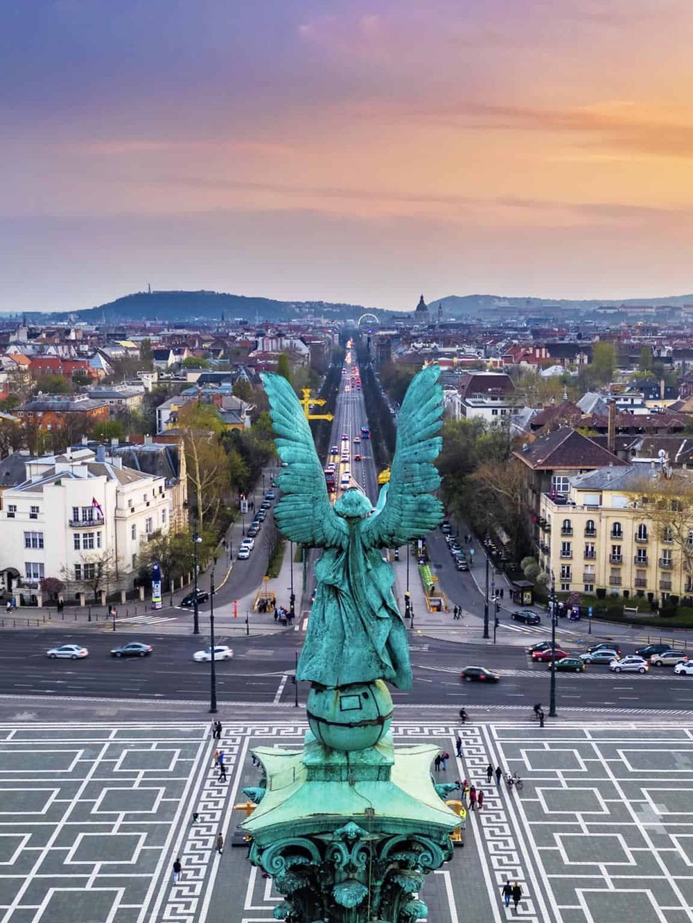 Majestic angel statue overlooking Vienna cityscape at sunset, iconic landmark for tourists and travelers.