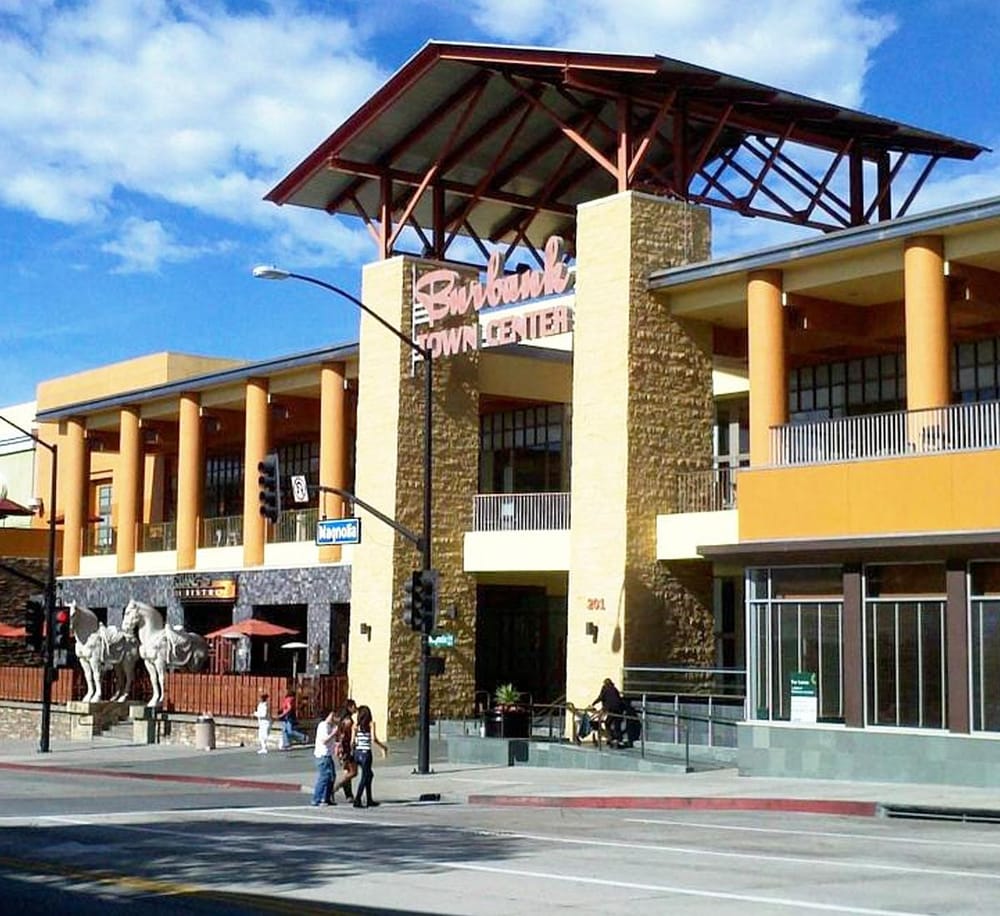Modern downtown shopping mall with vibrant architecture and pedestrian activity.