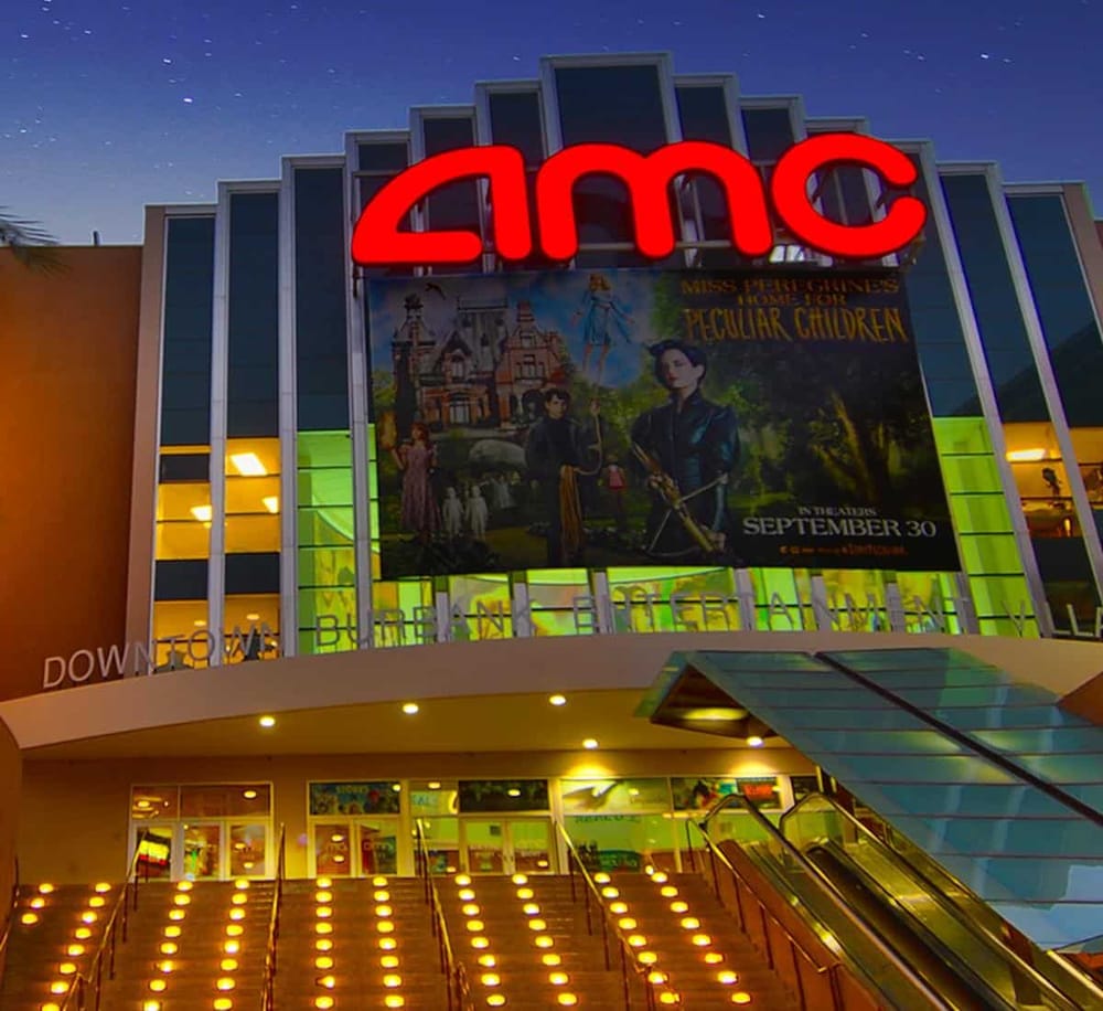 AMC theater marquee illuminated at night with QuestForDirections advertising.
