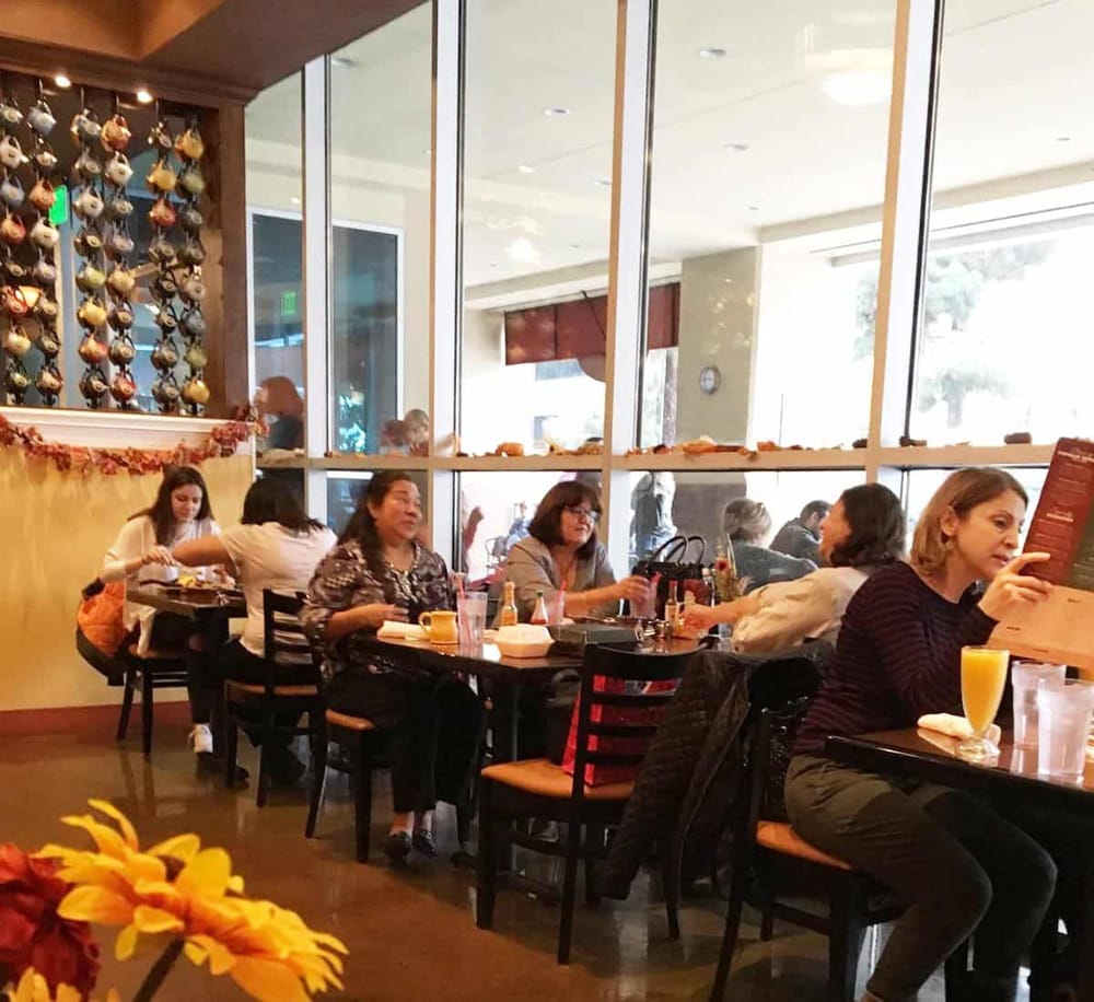 Cozy restaurant interior with guests enjoying breakfast and coffee, perfect for dining and socializing.